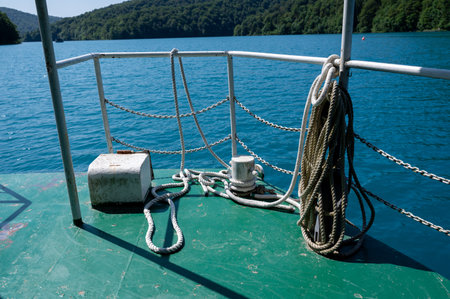 Railing of a boat on a lake with forest in the backgroundの写真素材