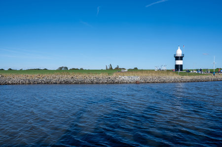 View of the "Kleiner PreuÃe" lighthouse and the fishing harbor from the North Sea, in the town of Wremen on the North Sea coast, in the Wursten district of Cuxhaven, Lower Saxony, Germanyの写真素材