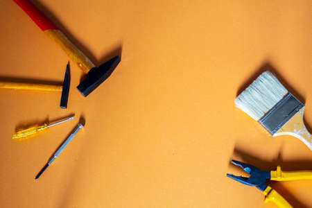 A top lay with a big brush, a pair of pliers, two hammers and two screwdrivers with copy space in...