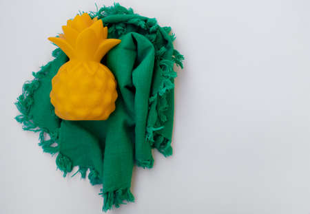 A fake pineapple on a green cloth. White backgroundの写真素材