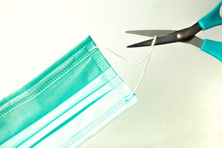 Protective mask and scissors on light background, closeup. Virus protectionの写真素材