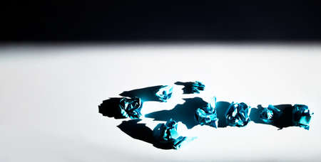 Blue crumpled paper on a white background with a shadow.の写真素材