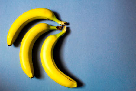 Bananas on a blue background. Top view. Copy space.の写真素材