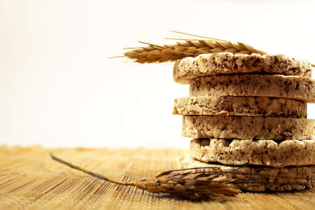 Oatmeal cookies on a wooden table with ears of wheat on a light backgroundの写真素材