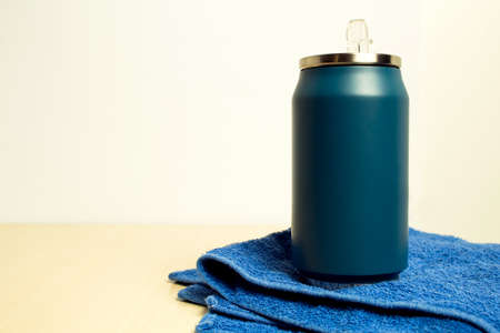 Blue thermos bottle and blue towel on a wooden table. Copy space.の写真素材