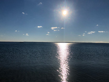 Sunset over the sea with sun rays and reflections on the water.の写真素材