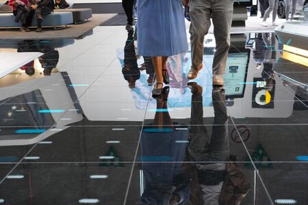 Visitors are walking around the exposition on reflecting black floor at Autosalon Genf 2019 in...