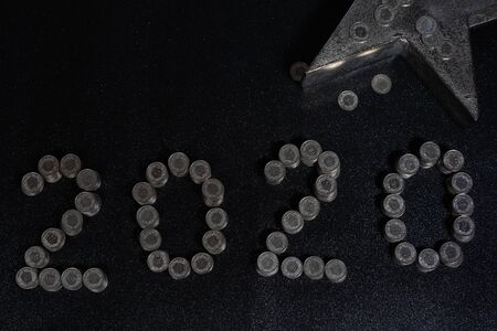 New Years 2020 graphic made from coins from Switzerland on a black shiny ground with silver star for...