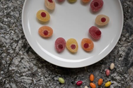 Easter candies in a raw in a white plate on a gray granite table. Concept, High angle view, space...