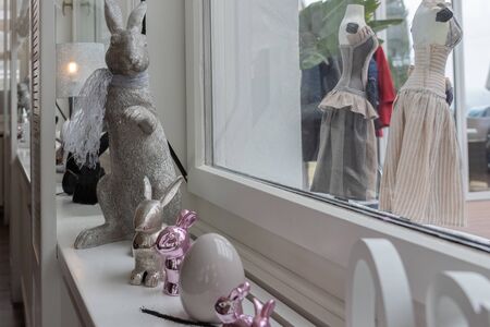 Easter bunnies sitting on sideboard in front of white bright window. Metal composition for Holiday concept.の写真素材