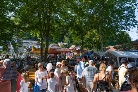 Children and adults talking and walking and visiting Lunapark and sitting under the trees in a sunny afternoon on the 4th of july at Jugendfest Brugg 2019.のeditorial素材