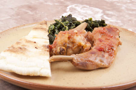 rabbit cacciatore served with spinach and cake aproteicaの写真素材