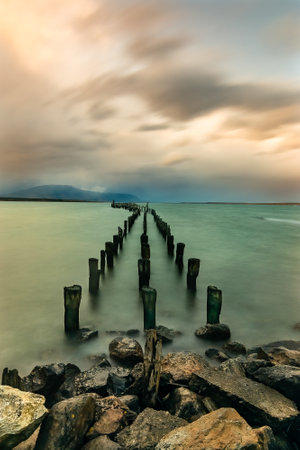 old wooden breakwater in the sea at sunset, long exposure photoの写真素材