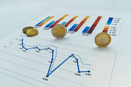 Euro coins on business diagram, on financial report, isolated on white