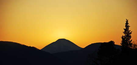 The sun has just set behind the mountains of San Leo. italyの写真素材