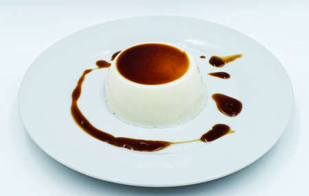 Panna Cotta with caramel sauce on a white plate. Delicious italian dessertの写真素材