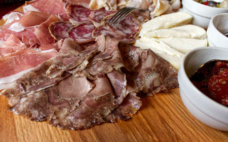 Rustic Emilian tray with typical products: prosciutto (ham), salami, coppa di testa, sliced cheese. Rocca Pitigliana, Bologna, Italyの写真素材