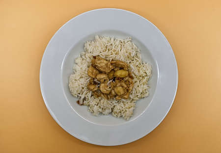 Chicken with almonds and basmati rice on orange backgroundの写真素材