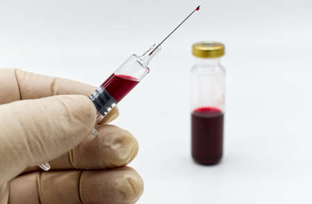 Doctor hand in rubber medical glove holding a syringe for vaccination. Selective focusの写真素材