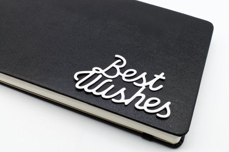 Black leather notebook with best wishes text on the coverの写真素材