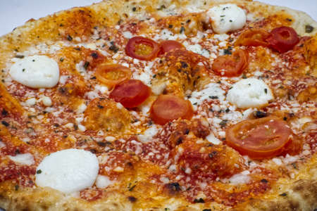 Pizza with tomatoes and Buffalo Mozzarella cheese from Campania region. Closeup