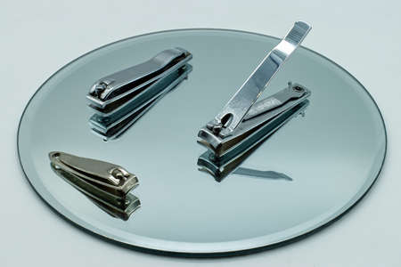 Set of nail clipper on reflective display.