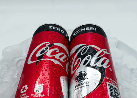 Bologna - Italy - July 12, 2021: Cans of Coca Cola on ice with water droplets.