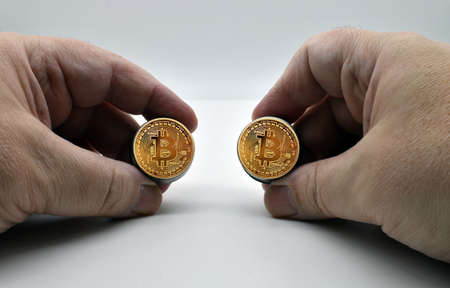 Hands of caucasian male holding golden Bitcoin money isolated on white background
