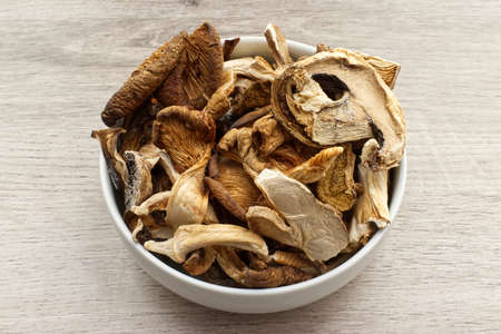 Dried mushrooms in a bowl isolated on wooden background