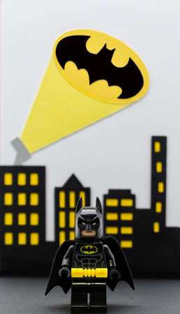 Bologna - Italy - December 12, 2021: Lego Batman miniature against Gotham City background. Batsignal from the rooftops.のeditorial素材