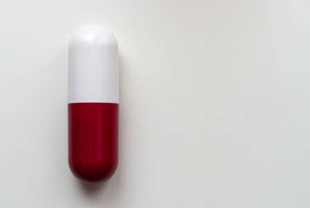 Big red and white capsule pill isolated on white background. Pharmacy concept. Copy space.の写真素材