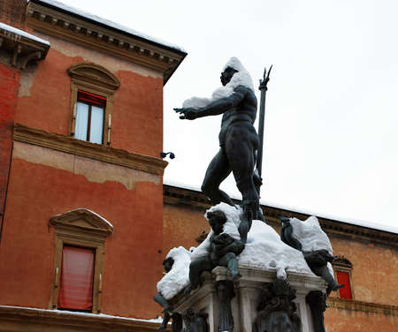 The Neptune fountain under the snow in winter time. Snowfall in Bologna. Italyの写真素材