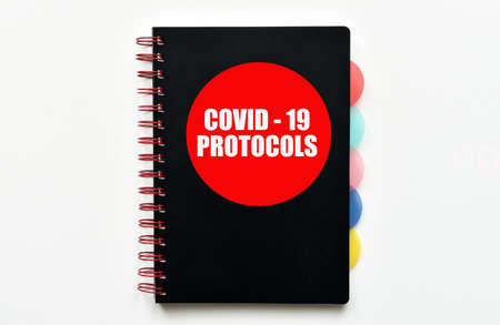Covid-19 Protocols. Handbook with Covid-19 Protocols isolated on white background.の写真素材