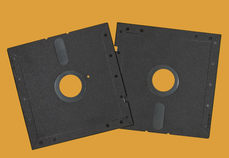Vintage Floppy Disk 5.25 inch. Retro storage technology isolated on orange background.の写真素材