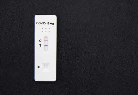 Positive test result of Covid-19 antigen test kit isolated on black background. Coronavirus...