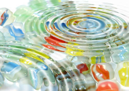 Coloured marble spheres toy under water wavesの写真素材