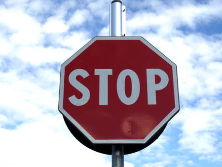 Stop traffic sign over blue sky with cloudsの写真素材