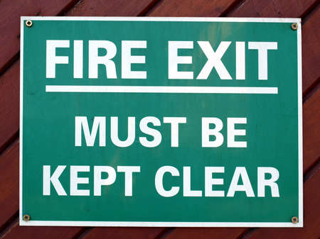 Fire exit sign with white text over greenの写真素材