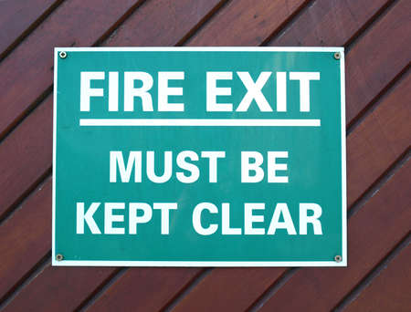 Fire exit sign with white text over greenの写真素材