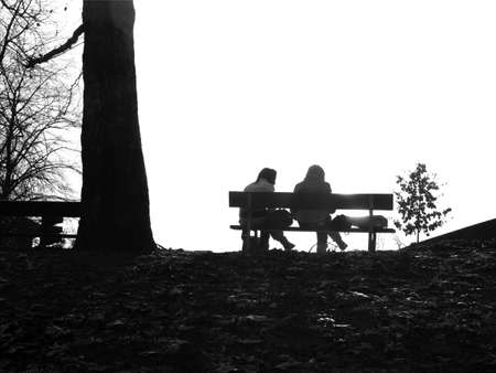 Two beautiful girls' silhouette against the sun with copyspace - in black and whiteの写真素材