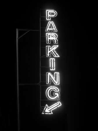 Parking sign neon light at night over dark skyの写真素材