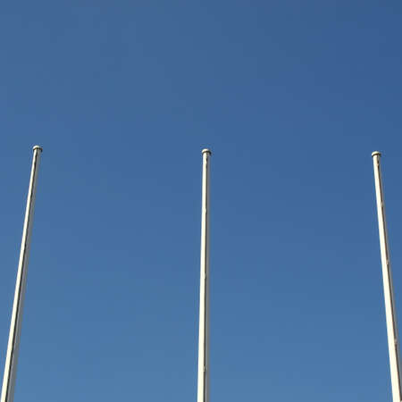 Flagpole flagstaff mast over a blue sky backgroundの写真素材