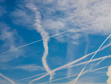 Blue sky with plane trails near major airportの写真素材