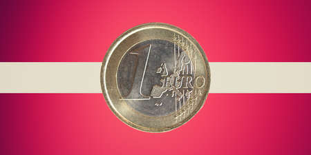 One Euro coin over the flag of Latvia, a country in the Baltic region of Northern Europe which adopted the Euro currency on January 1, 2014の写真素材