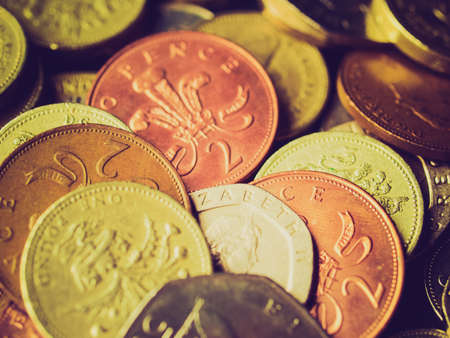 Vintage looking British Pounds coins (UK currency) over a dark backgroundの写真素材
