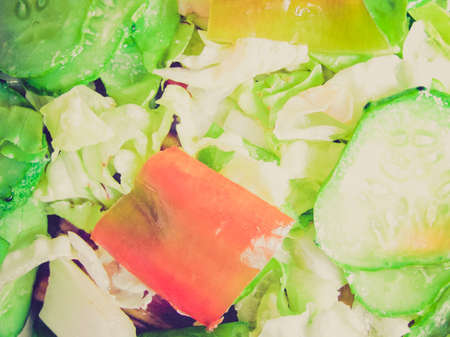 Vintage looking Green salad with lettuce and vegetables, peppers, cucumbersの写真素材