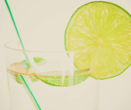Vintage looking Cocktail mixed alcoholic drink with lime and peppermintの写真素材