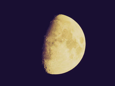Vintage looking The moon over dark black sky at nightの写真素材