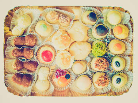 Vintage looking Mixed pastries with chocolate, cream, fruit useful as backgroundの写真素材