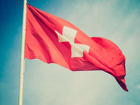 Vintage looking Flag of Switzerland over a blue skyの写真素材